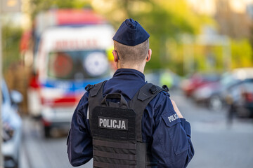 Policjant z radiowozem w akcji wieczorem. Policja © FotoDax