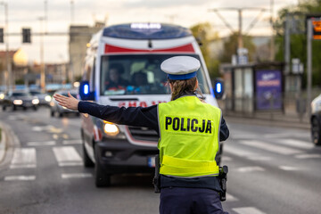 Policjantka ruchu drogowego kieruje ruchem drogowym na ulicy.  © FotoDax