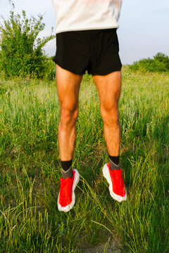 A trail runner is doing a vigorous warm-up in a field before practice