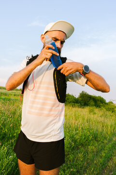 Runner Prepares for a Long Run With Hydration Pack on a Sunny Day