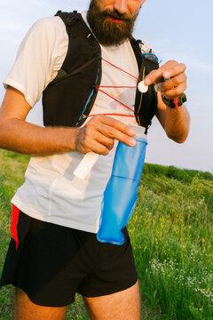 Runner Prepares Drink in a Bottle During Outdoor Activity 