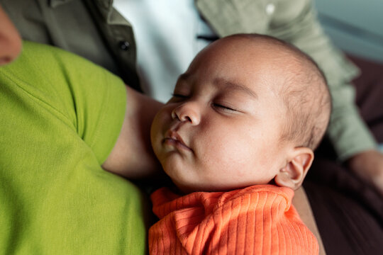 Diverse family parent holding sleeping newborn baby