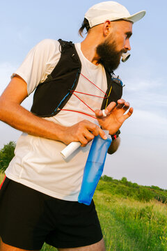 Runner Prepares Drink in a Bottle During Outdoor Activity 