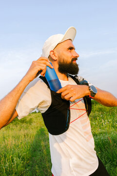 Runner Prepares for a Long Run With Hydration Pack on a Sunny Day