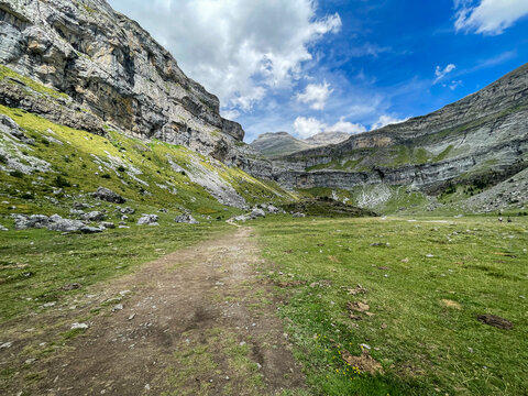 Parque Nacional de Ordesa y Monte Perdido hiking trail, grassy alpine valley with rocky cliffs and path