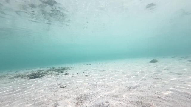 Shallow underwater sandy seabed with ripple patterns and rocks in clear turquoise ocean water, natural marine background, 4K_1_IMG_5211_15s_0,03.MOV.mov