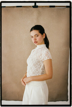 Woman wearing white lace shirt in studio