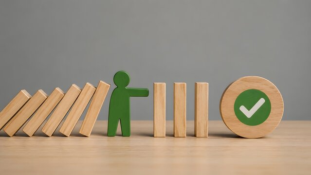 Crisis management intervention and business continuity concept as green figure stops falling dominoes to protect validation checkmark.
