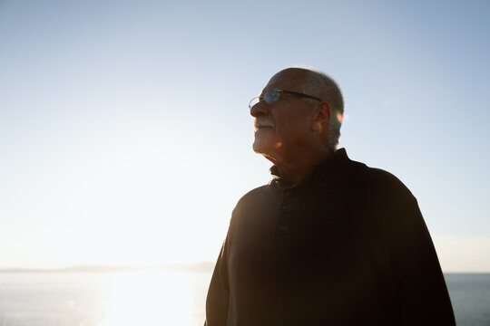 Contemplative senior man outdoor portrait at sunset with warm light