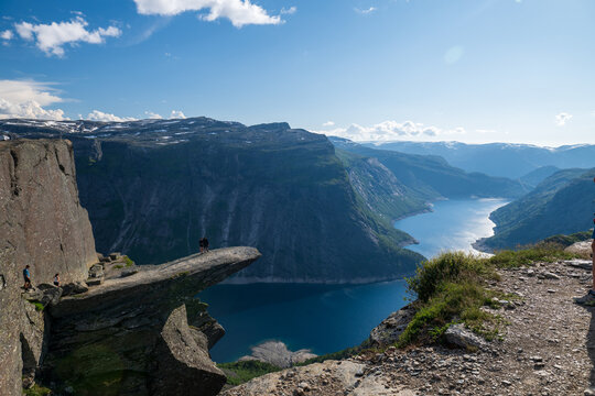 Aerial landscape of Trolltunga rock ledge overlooking a blue fjord and mountain plateau in Norway on a clear summer day.