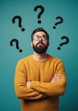 Thoughtful Man with Beard and Glasses Looking Up with Question Marks Over His Head on Teal Background