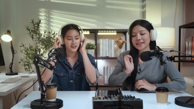 Podcaster content influencer creator podcast recording studio microphone headphone conversation guide, friendly talk between two women with smile and calm focus, cozy setup with audio mixer mic arm