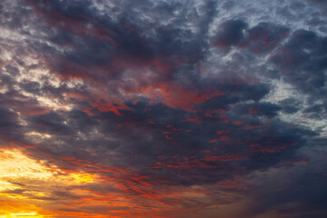 Fototapeta premium Stunning Vibrant Sunset Sky with Dramatic Colorful Clouds,A breathtaking and dramatic sunset sky filled with vibrant golden, orange, purple, and dark blue clouds, creating a peaceful and inspiring.