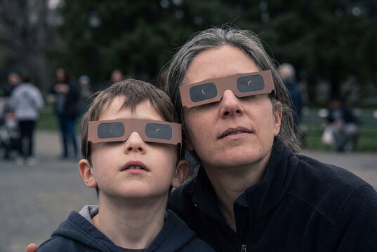 Parent and Child Watching a Solar Eclipse with Protective Glasses