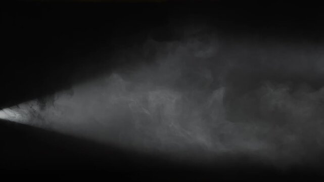 A single white spotlight shines through dense drifting smoke on a black background. Concept of overlay real effect, theater, concert, cinema, advertising, presentation, and dramatic visual design.