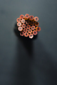 Yellow number two wooden pencils on dark blue gray background in natural light.