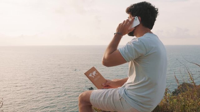 Young remote worker talking on the phone with a sea view