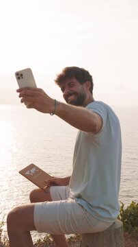 vertical Young man taking a selfie during his adventurous trip by the sea