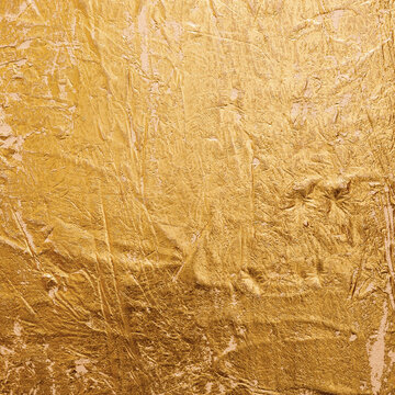 Textured golden stucco background with scratches, scuffs and stains. Plaster backdrop of yellow color for copy space.