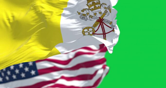Vatican city flag waving in the wind with the American flag isolated on green background