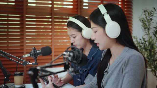 Podcaster podcast recording studio microphone headphone content influencer creator woman in home setup with smartphone laptop tablet coffee two women conversation, audio production for social media