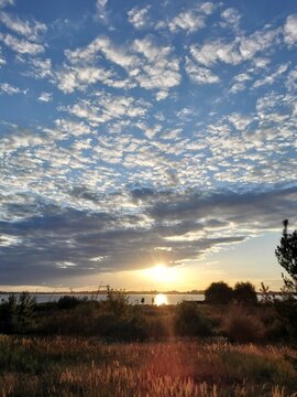 A beautiful sunset over the lake with cirrus clouds and rays of light.