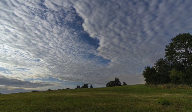 Wolkenstimmung im Fr&uuml;hlicht des Tages an den Feldern am Ortsrand auf dem Lande
