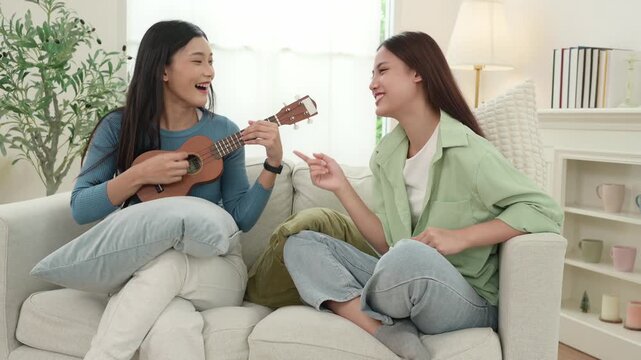 Happy Girls Enjoy Time Together on a Cozy Sofa While Playing Music in a Bright Living Room