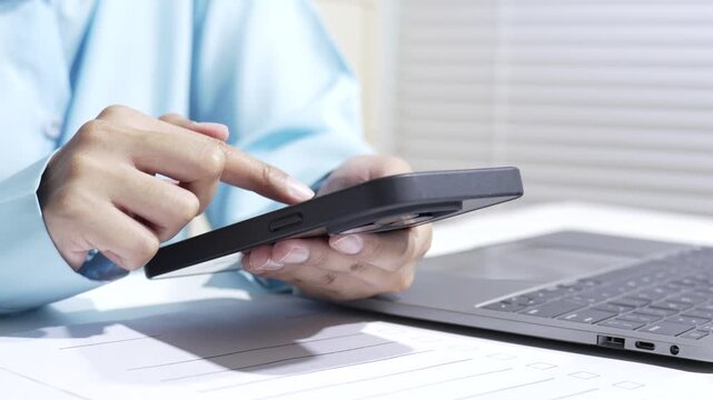 Person hand smartphone laptop office workspace desk technology communication typing close up digital device online work concept in modern business environment
