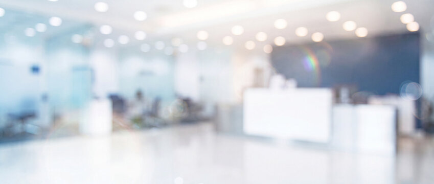 Blurred modern office reception hall background featuring bright soft light bokeh, clean white interior, and wide panoramic perspective ideal for corporate website headers and banners