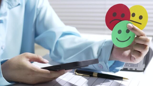 Emotional feedback evaluation with mobile device and hand holding happy sad neutral face, person holding tablet and emotion card office expressing mood feedback and quality
