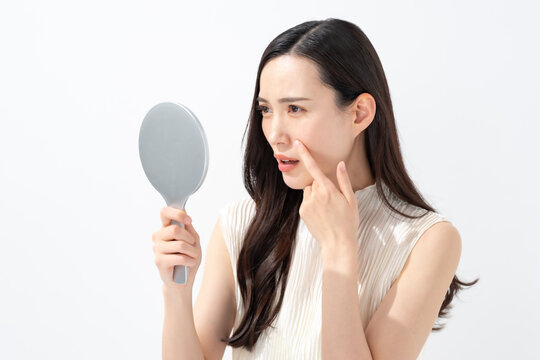 鏡を見て鼻を気にする女性