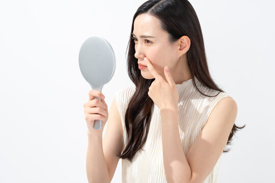 鏡を見て鼻を気にする女性