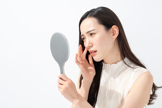 鏡を見て鼻を気にする女性