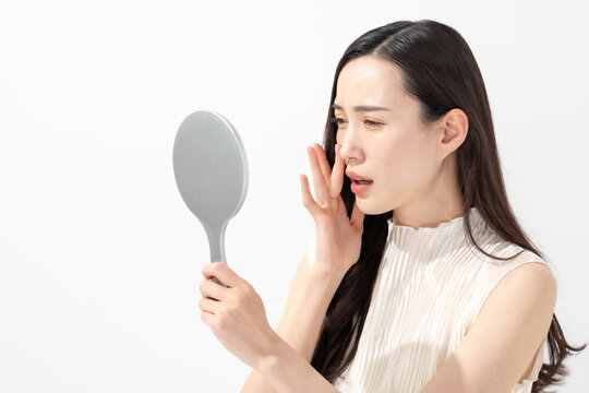 鏡を見て鼻を気にする女性