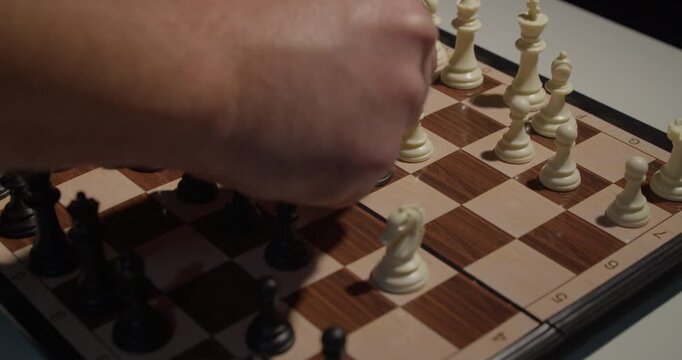 close up of chess pieces being moved on a board