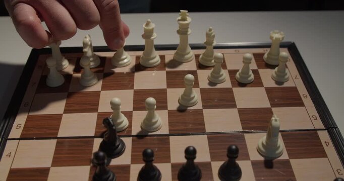 close up of hand moving chess piece on board