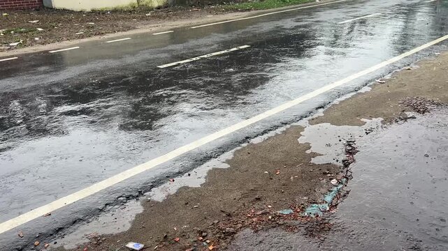 Local Commute in Heavy Rain: Blue Auto Rickshaw Driving on Asphalt Road in Gaibandha