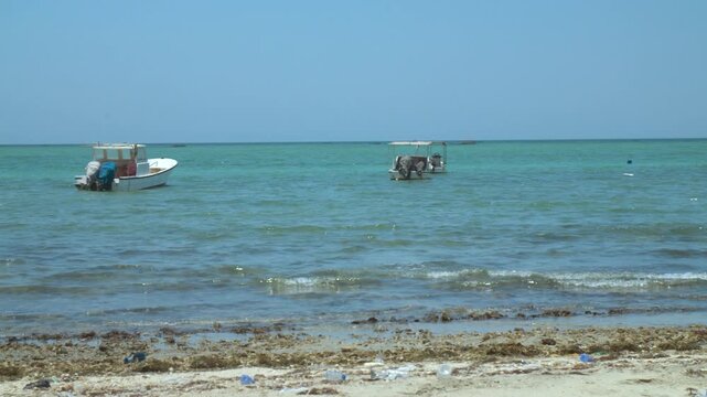 Fishing boats anchored at a dirty beach on a windy day