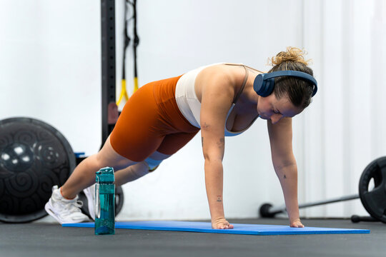 Woman with prosthetic leg doing plank exercise enjoying inclusive fitness