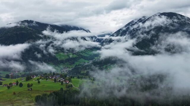 Aerial View of Fog and Low Clouds Rolling Over Forested Alpine Valley