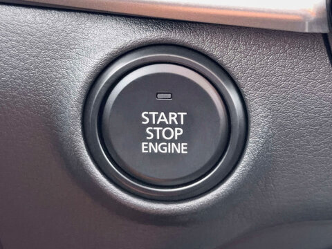 Closeup of a car engine start stop button on the dashboard