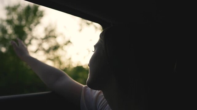 Woman experiences freedom road hand reaching out car window. Freedom felt through hand waving. freedom open road with woman hand out window. Woman freedom on scenic road. Woman road escape into nature