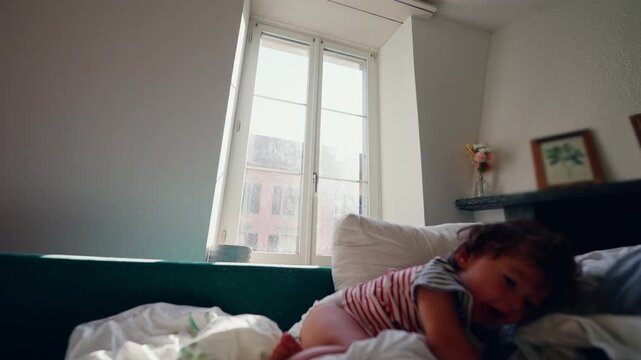 Toddler airborne while jumping from couch at home, dynamic childhood action expressing carefree freedom, bold adventure, confidence and playful excitement