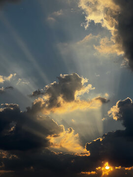 Sunbeams breaking through dark clouds at sunset