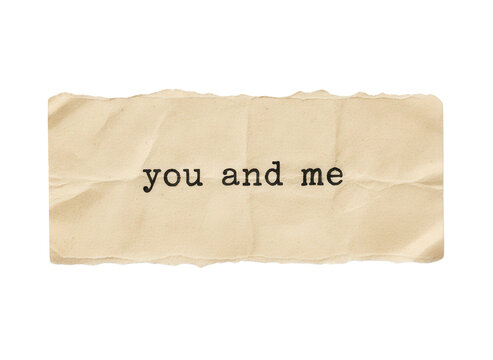 Old torn piece of beige paper with the words you and me typed in black ink