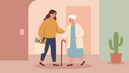 Fototapeta premium Kind volunteer supports an elderly woman with a walking cane while carrying her grocery bag in a warm interior.