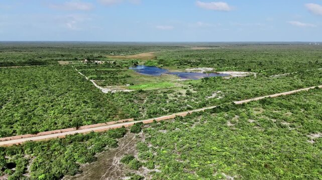 Aerial View of Small Lagoon and Farmhouse Among Rural Scrubland