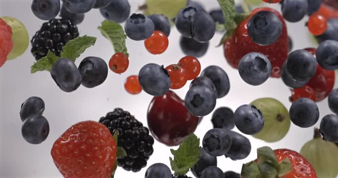 Mixed fresh berries floating in super slow motion 