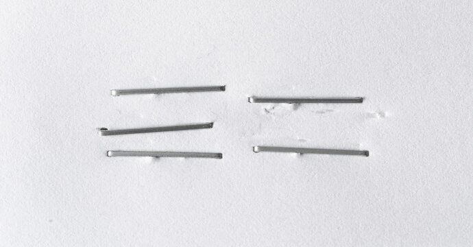 Staples pushed into a paper, metal office staple needles